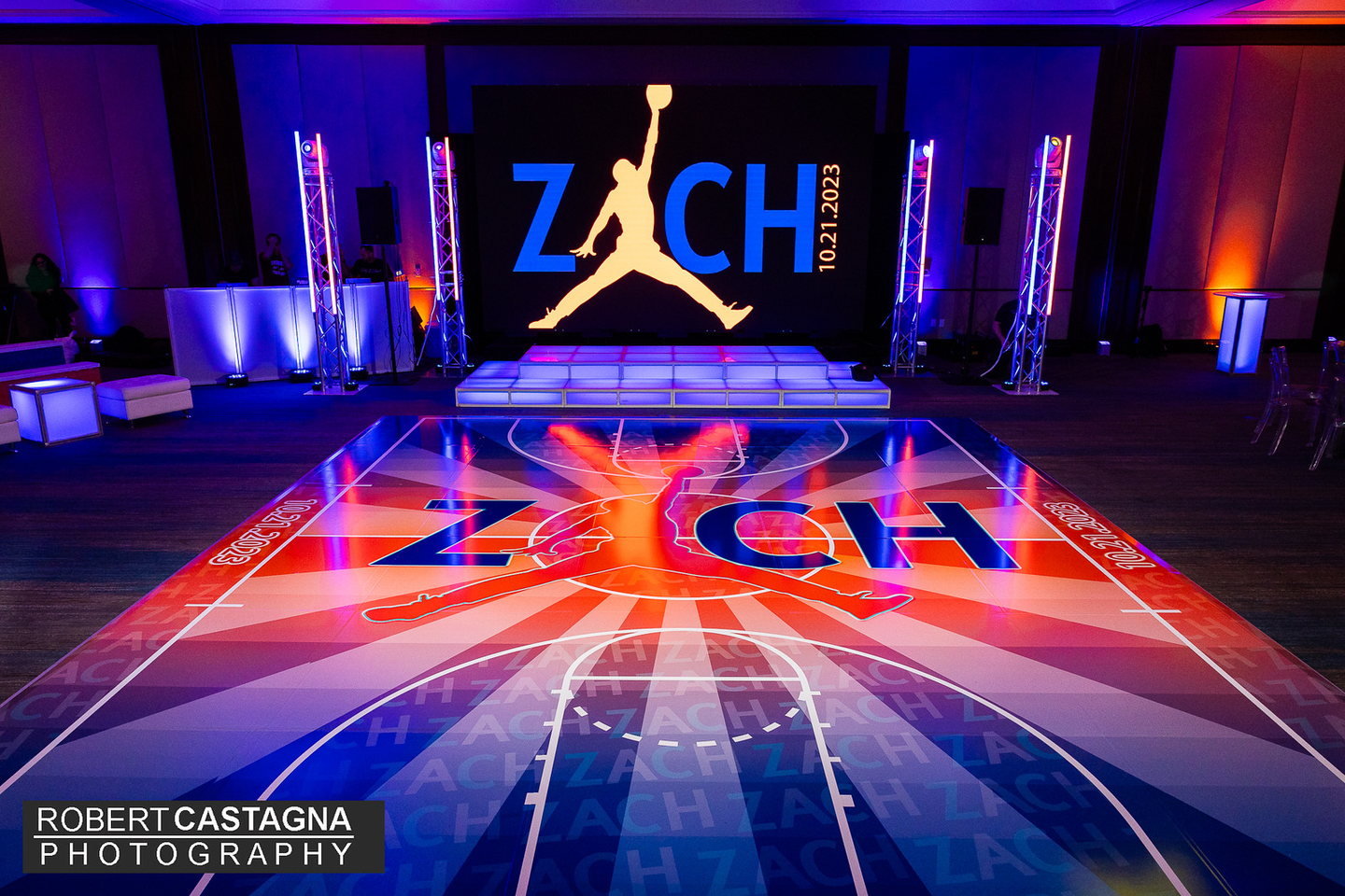 Custom basketball court dance floor wrap with a branded illuminated stage and DJ environment