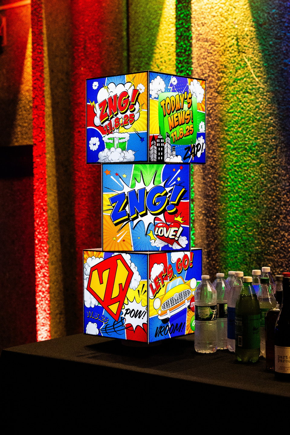 Stacked custom comic-book graphic cube centerpiece with personalized event artwork