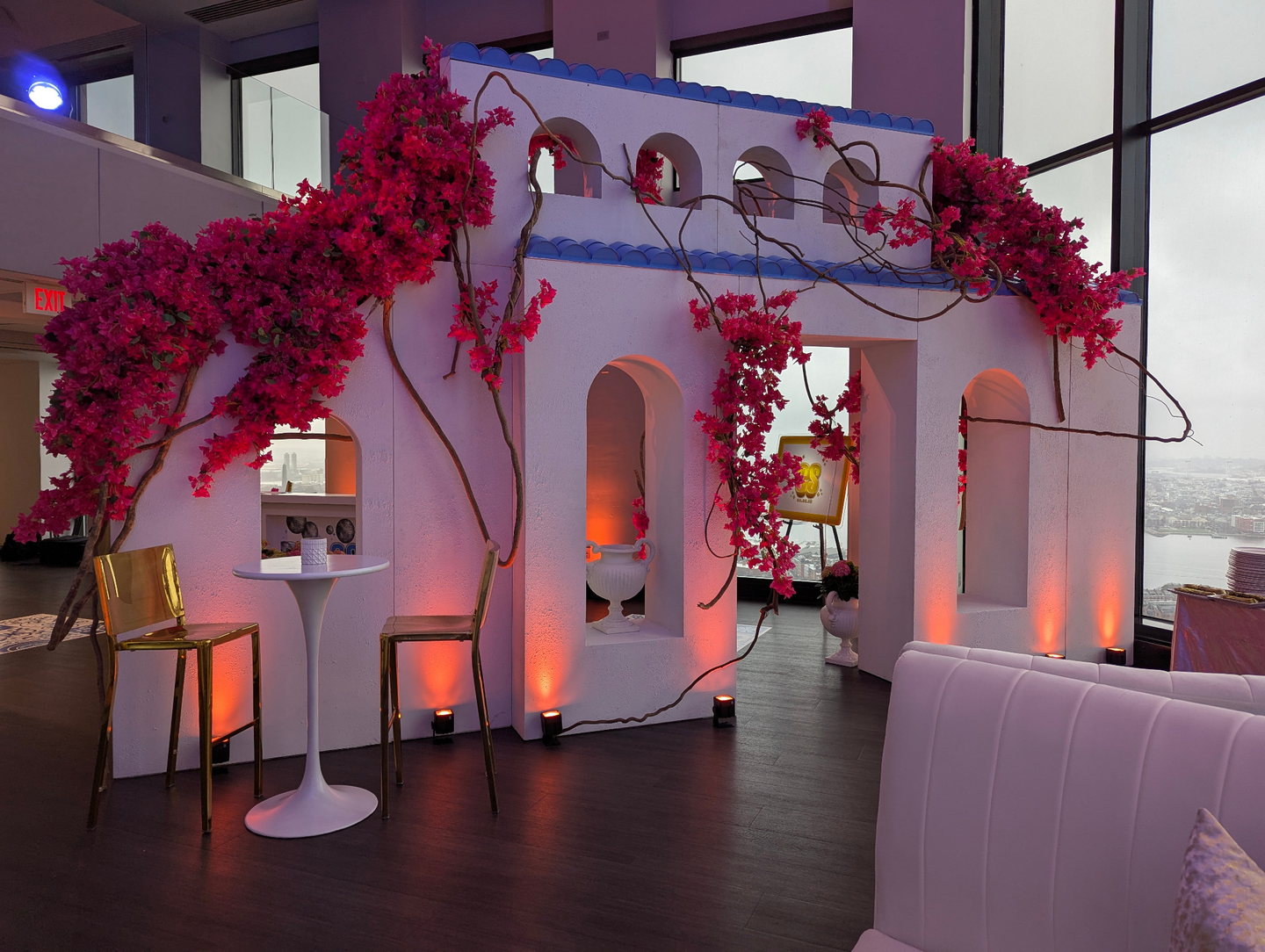 Greek-inspired custom scenic facade with arches, bougainvillea, architectural details and uplighting