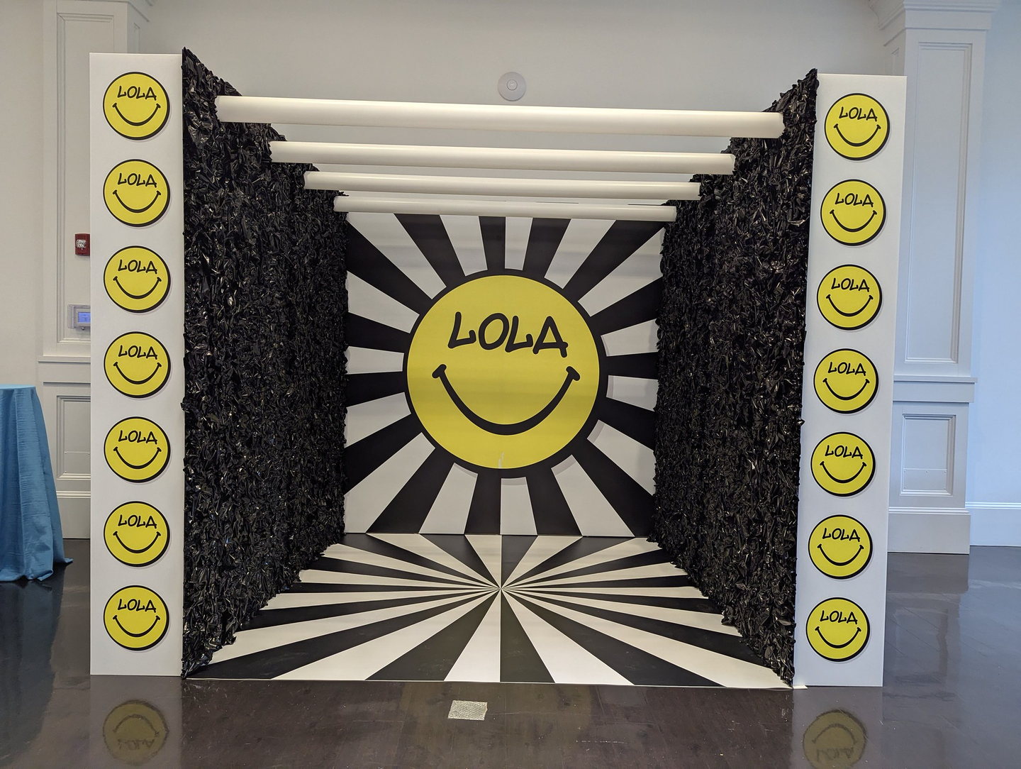 Custom black, white and yellow LOLA photo room with a graphic floor, scenic walls and overhead elements