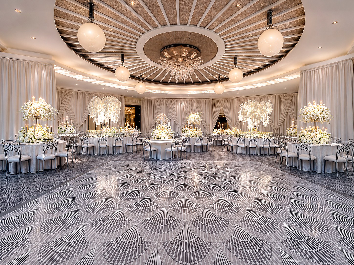 Luxury white wedding ballroom with a full custom patterned dance floor wrap, floral tables and candlelight