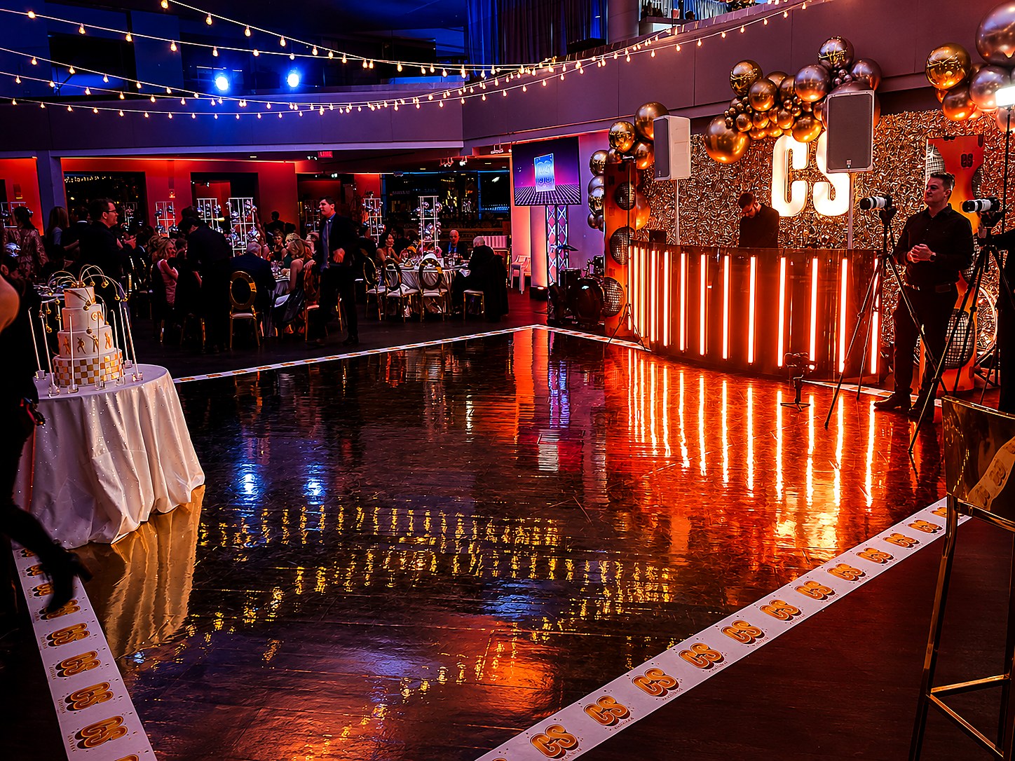 Custom reflective dance floor, illuminated DJ booth and branded event environment for a mitzvah