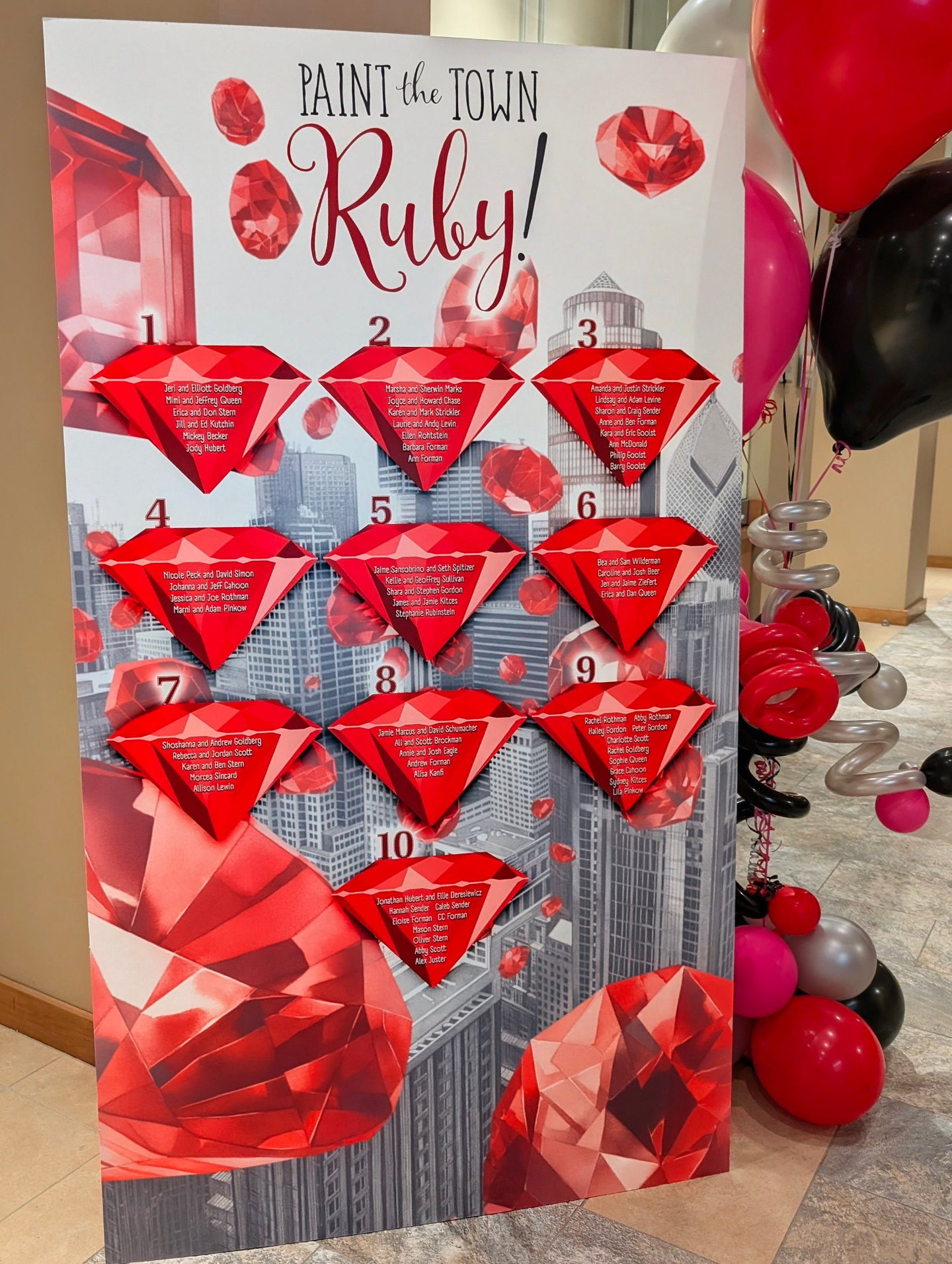 Ruby-themed seating chart with dimensional red gemstone table assignments and city graphics